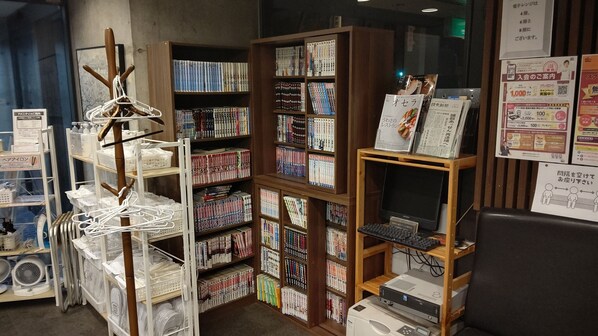 A bookstore with shelves of books, a computer, and a sign with Japanese text. - Tsuyama Central Hotel Annex (Tsuyama)