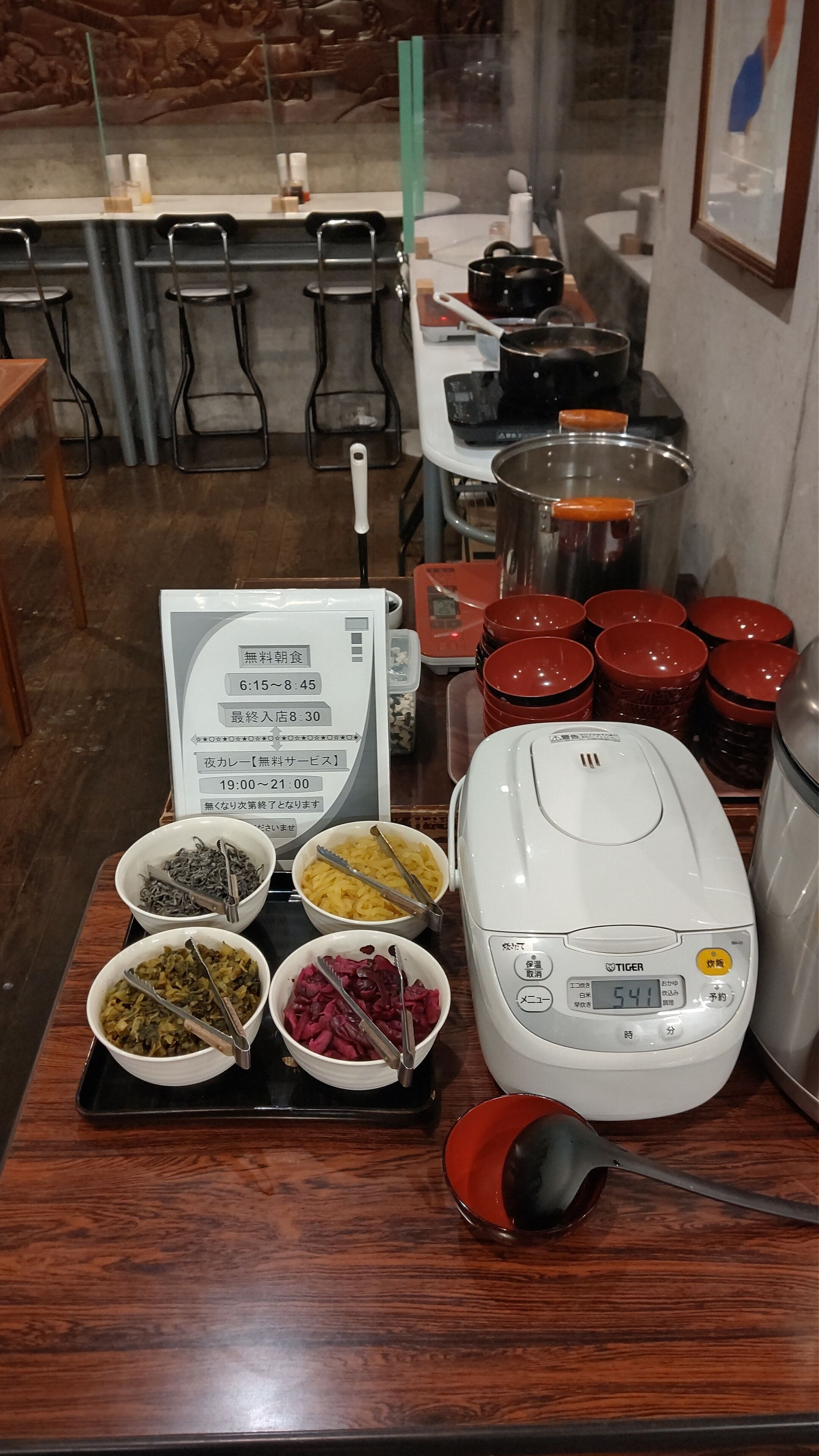 A buffet setup with various food items and a rice cooker.