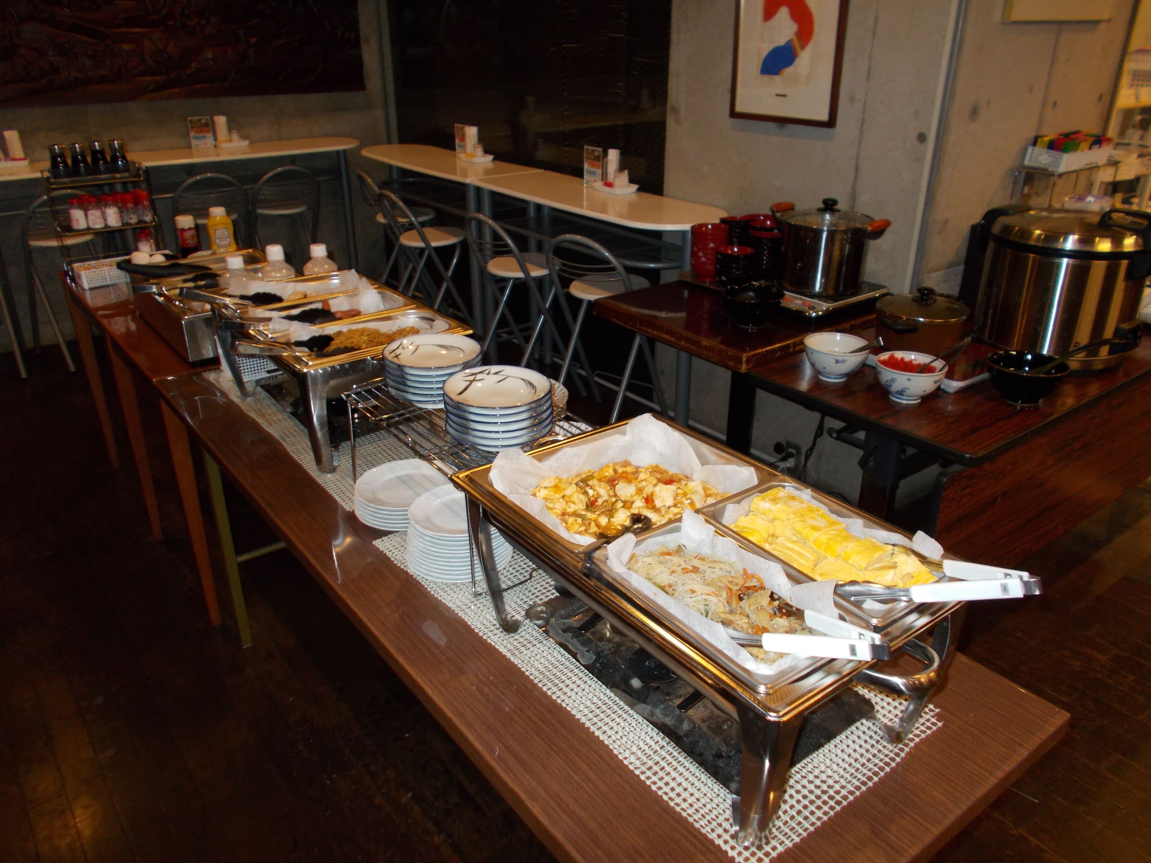 A buffet setup with various food items and serving utensils.