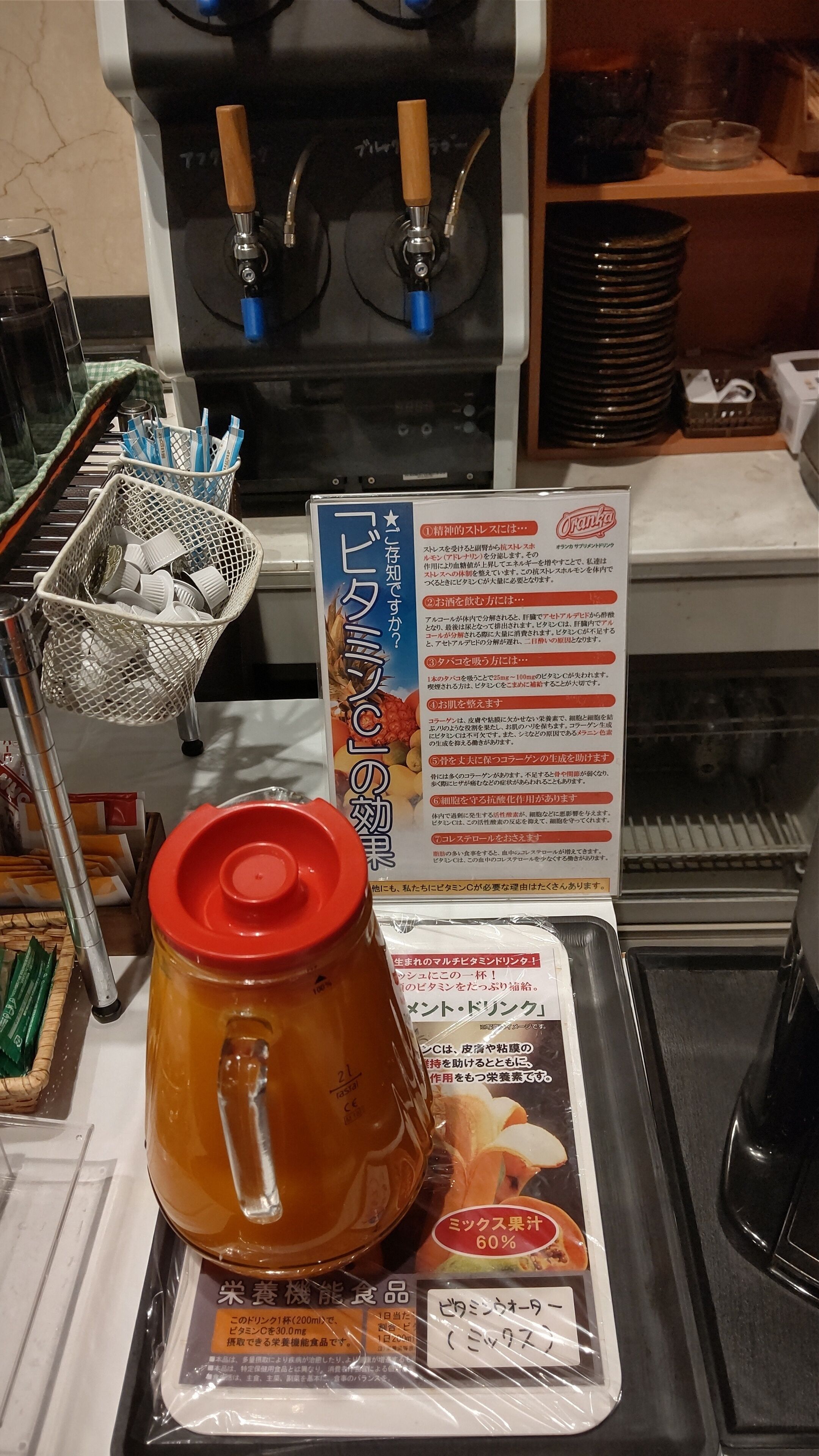 Una máquina de café con un cartel de menú, una cafetera y una bandeja con una bebida y un paquete.