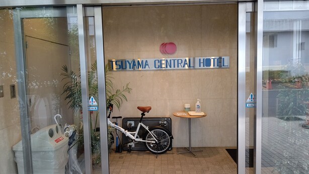 La entrada del Hotel SuYama Central con una bicicleta estacionada en el interior.