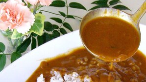 A bowl of white rice topped with a brown sauce.