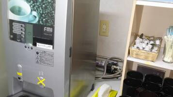 A coffee machine with a digital display, a water dispenser, and a coffee pod holder.