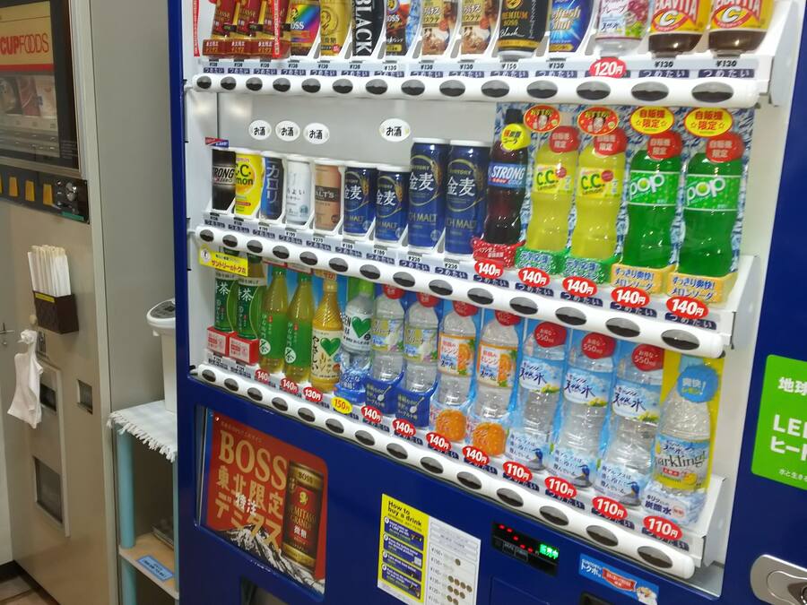 A vending machine with various drinks and snacks, including bottles of water, sodas, and other beverages.