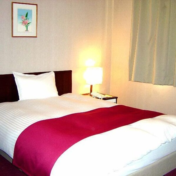A hotel room with a bed, a nightstand, a lamp, and a framed picture on the wall. - Hirosaki Grand Hotel (Hirosaki)