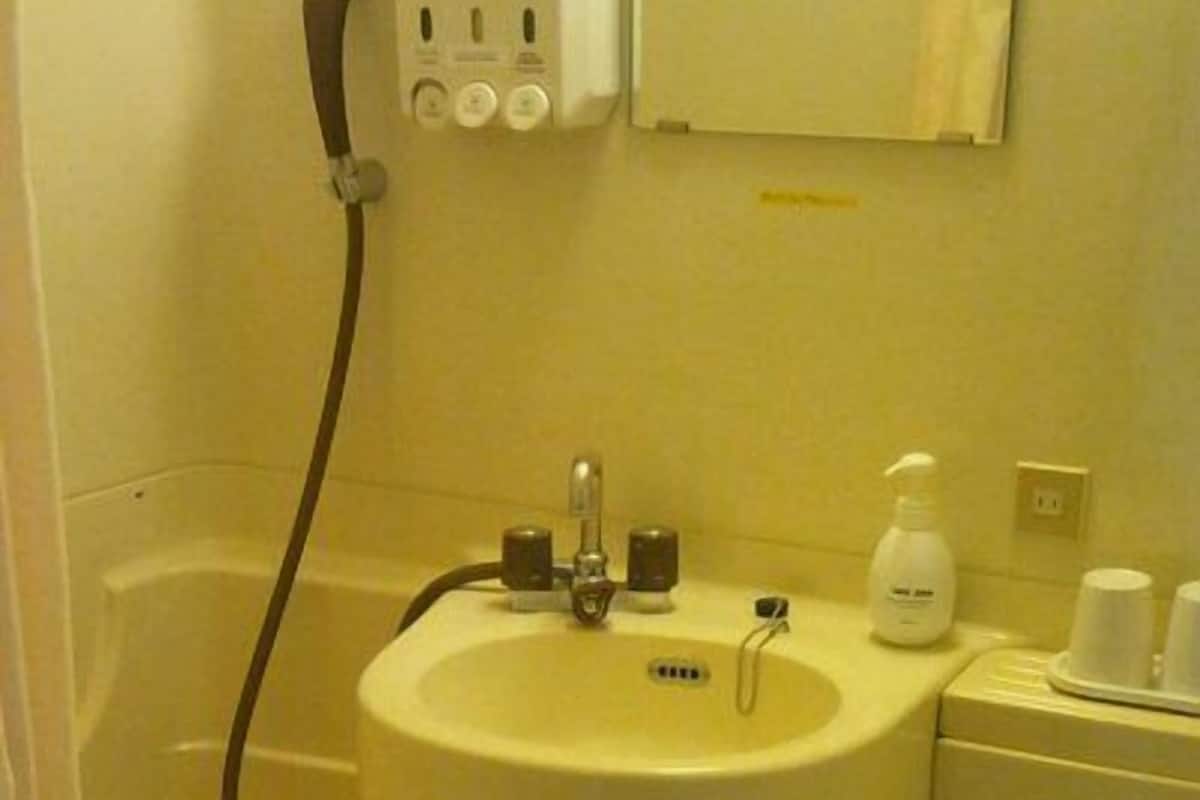 Ein kleines Badezimmer mit Waschbecken, Toilette und Handtuchhalter.