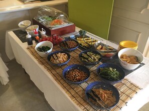 A buffet table with various food items and condiments.