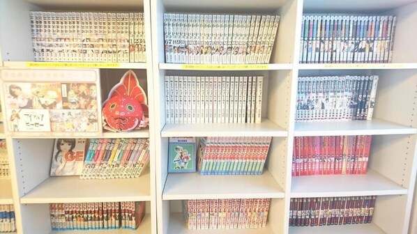 Una estantería con varios volúmenes de manga organizados por serie.