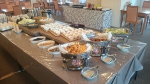 A buffet table with various food items and serving utensils. - Mito Riverside Hotel (Mito)