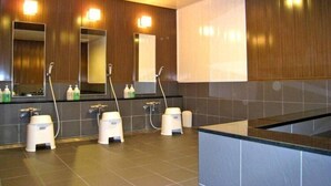 A modern bathroom with three sinks, each with a mirror and handheld showerhead, and a large vanity area with a countertop. - Mito Riverside Hotel (Mito)