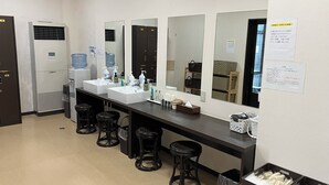 A restroom with two sinks, a mirror, and three stools. There are water dispensers and hand soap on the counter. - Hotel CROWN HILLS MIYOSHI (Miyoshi)