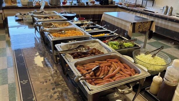 A buffet with various food items including sausages, noodles, and salads. - Hotel CROWN HILLS MIYOSHI (Miyoshi)