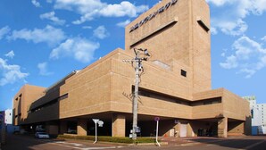 A large, modern building with a prominent tower and a sign indicating it is a museum. - Nagaoka Grand Hotel (Nagaoka)