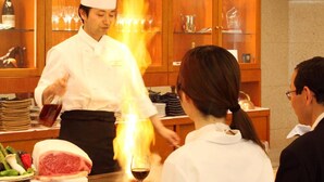 A chef preparing food at a restaurant counter with a customer seated nearby. - Nagaoka Grand Hotel (Nagaoka)