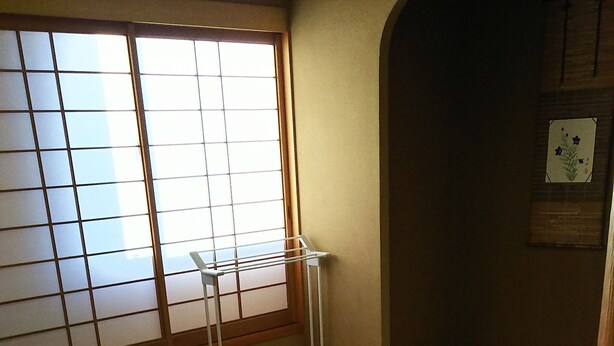 Una habitación japonesa tradicional con suelo de tatami, una mesa de madera baja y un panel shoji.