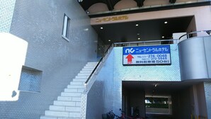 Una escalera conduce a un segundo piso, con un letrero que indica una zona de negocios o servicios.