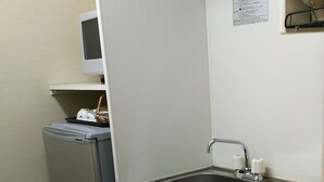 Cocina compacta con refrigerador, pileta y microondas.