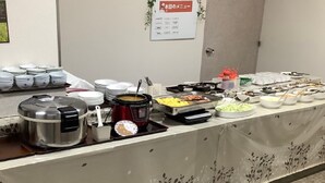 A buffet setup with various dishes and utensils.