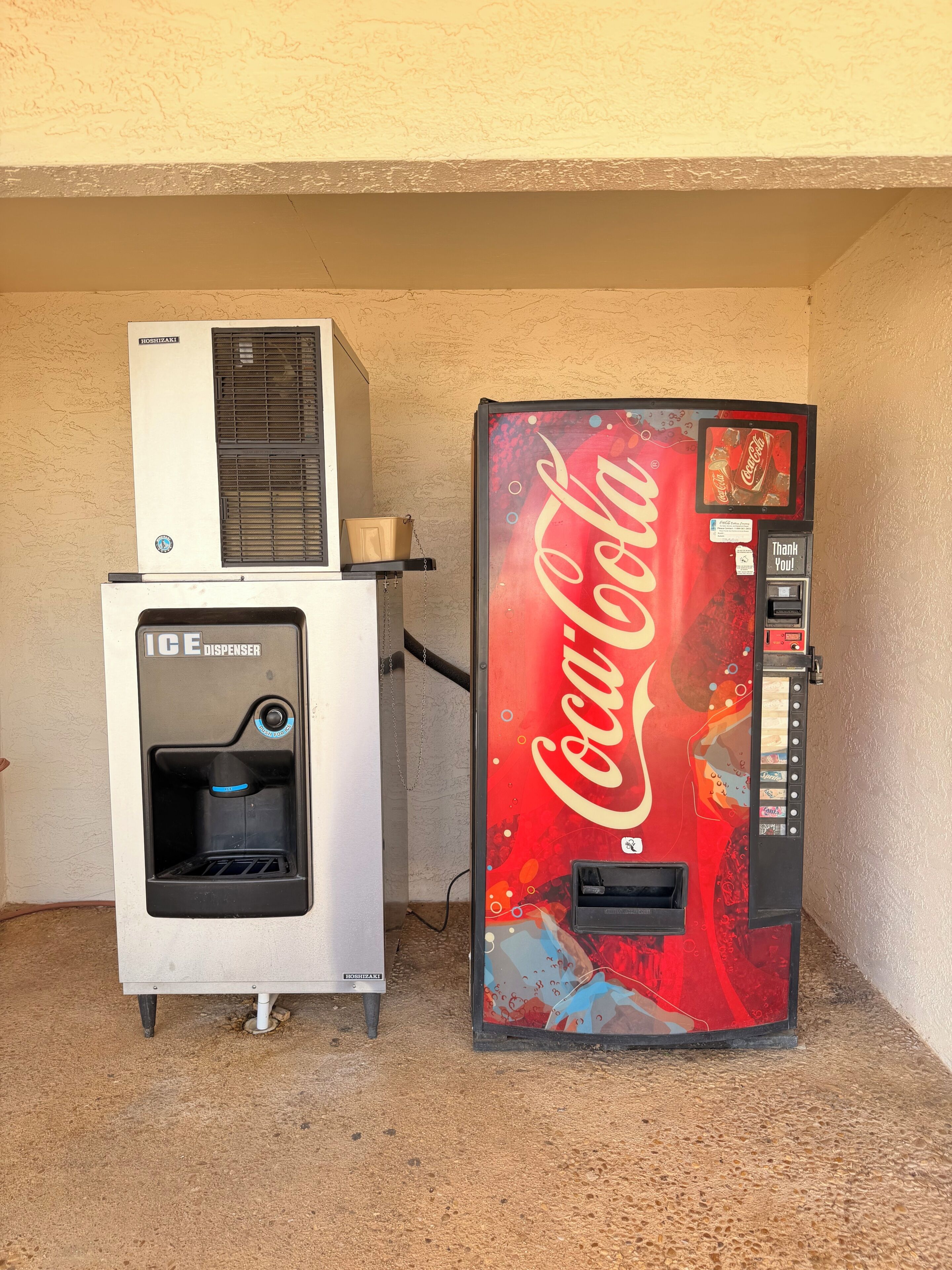 Automaatti, jossa on Coca-Colan logo, ja sen päällä on vesihana.