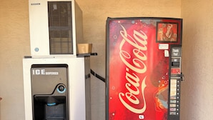 A vending machine with a Coca-Cola logo and a water dispenser on top.