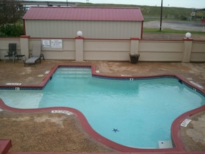 A rectangular swimming pool with a red border and a sign indicating a depth of 3 feet 6 inches. - Royal Inn Pearsall (Pearsall)
