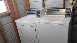 A front view of a white Whirlpool washer and dryer unit with a control panel on top. - Royal Inn Pearsall (Pearsall)