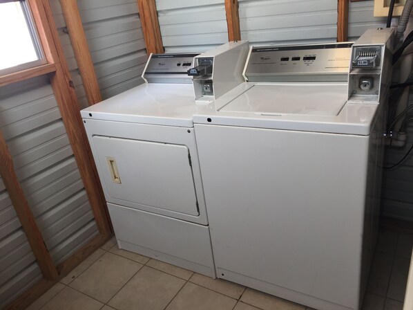 Vista frontal de una lavadora y secadora Whirlpool blancas con un panel de control en la parte superior.