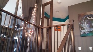 Una escalera con barandillas de madera y de cristal, que conduce a un piso superior.