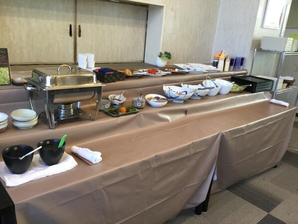 A buffet setup with various dishes and utensils.