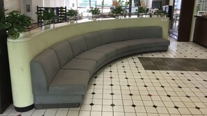 Un espace détente aux lignes courbes, doté d’un sol carrelé et d’un comptoir d’accueil.