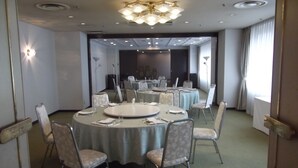 A conference room with round tables, chairs, and a chandelier. - Ichikawa Grand Hotel (Ichikawa)