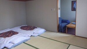 A room with tatami flooring, a low wooden ceiling, and a sliding door leading to another room. - Ichikawa Grand Hotel (Ichikawa)