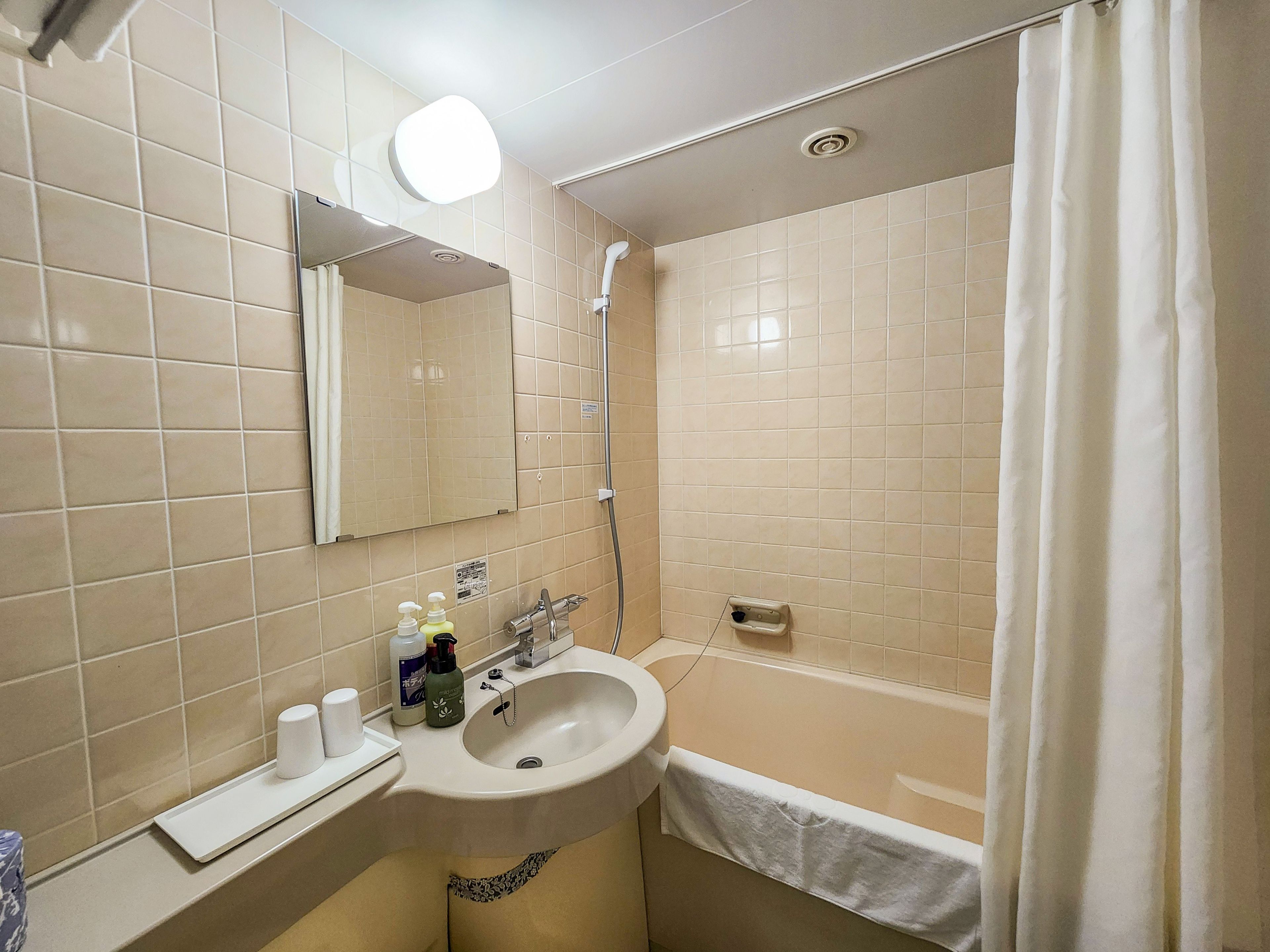 Un bagno con lavandino, specchio e doccia.