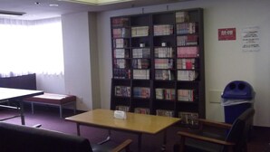 Una biblioteca con estanterías, una mesa y sillas.