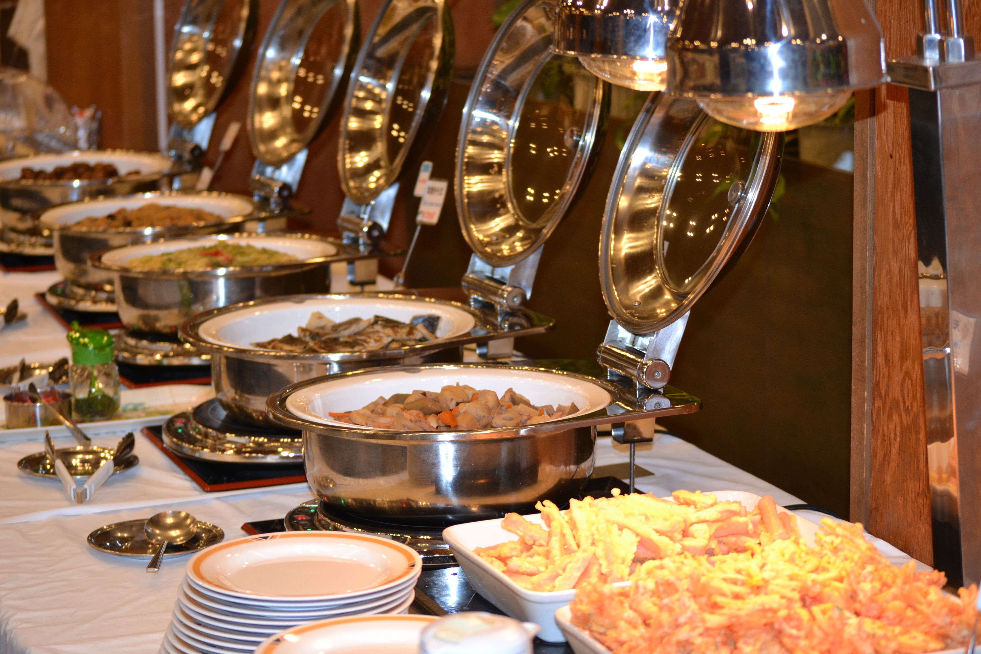 A buffet with various dishes and utensils.