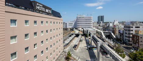 A JR-East Hotel Mets building with a modern design, located in a busy urban area with a clear sky.