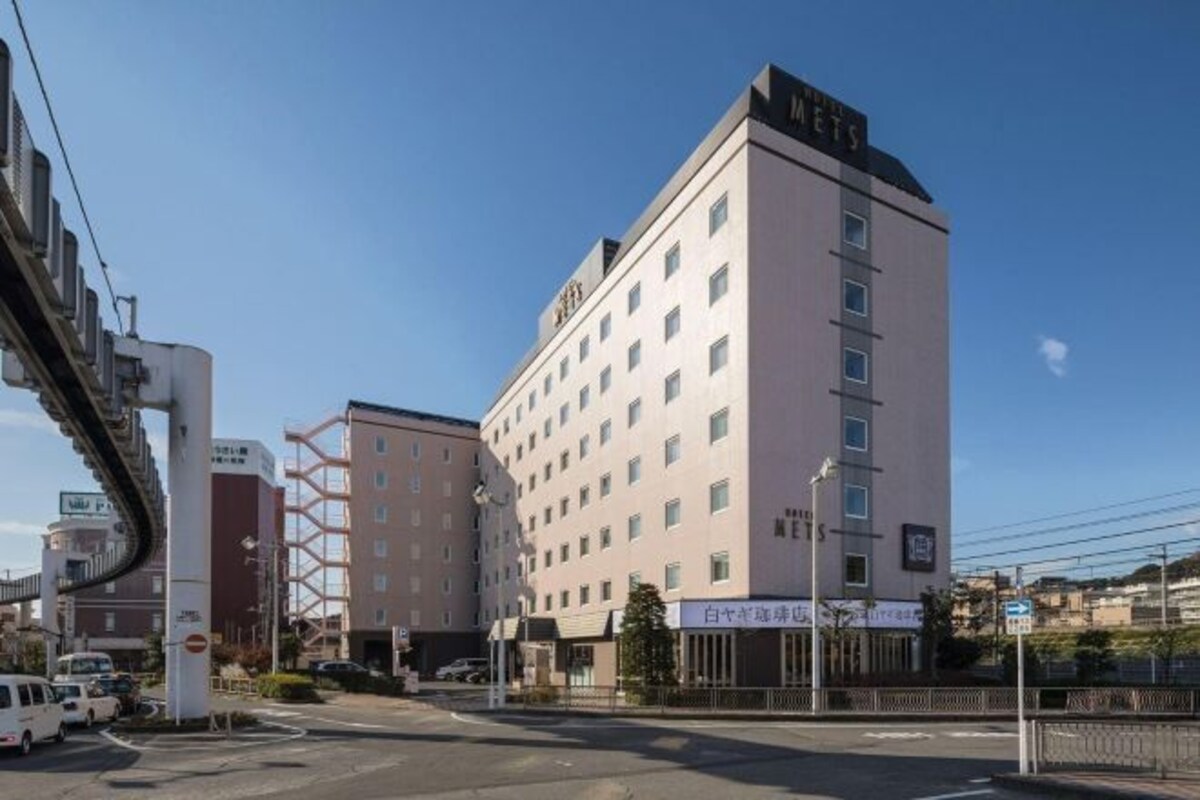 Un hotel de diseño moderno, con un llamativo letrero 'MET' en la parte superior.