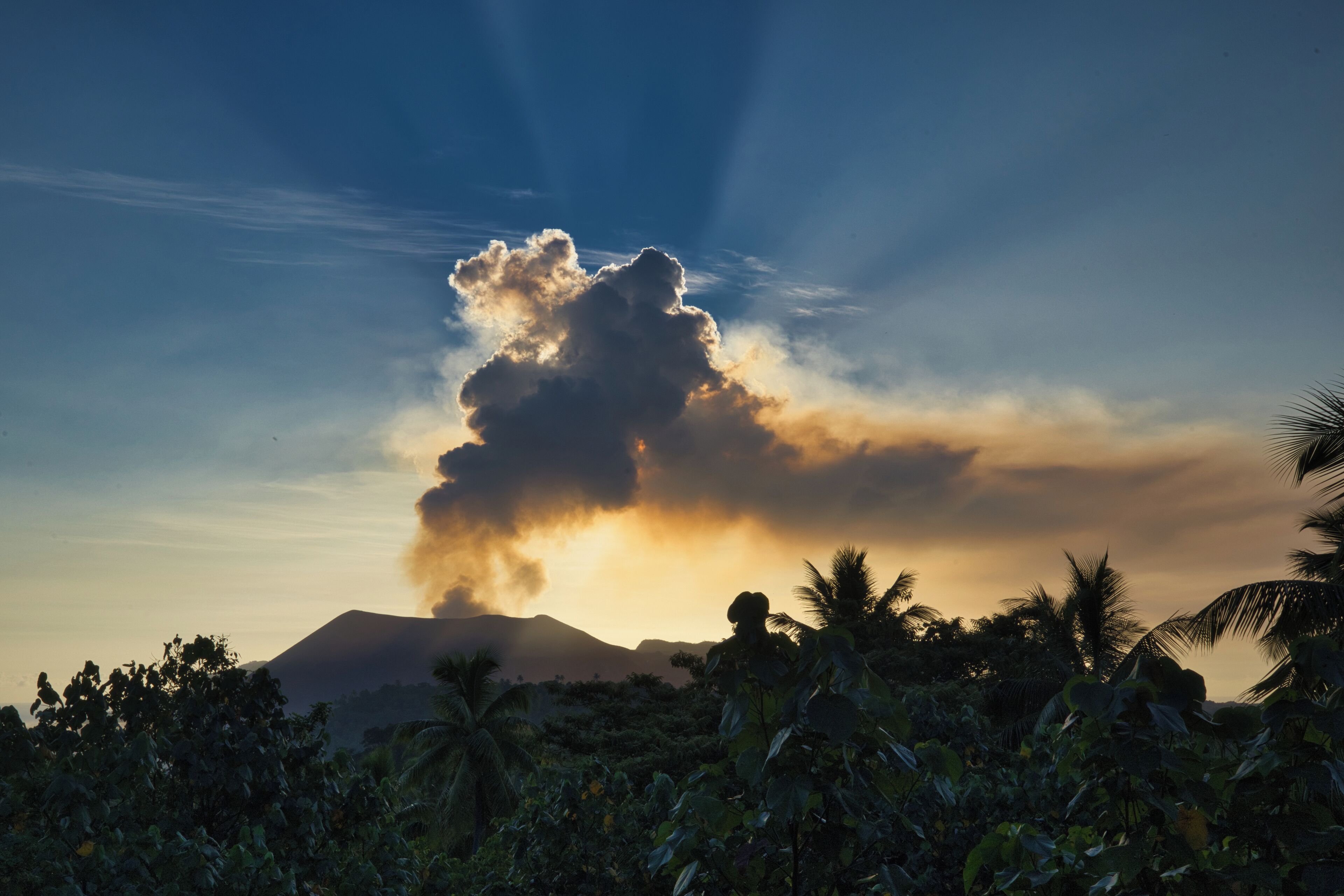Una montaña con una formación de nubes y luz solar.