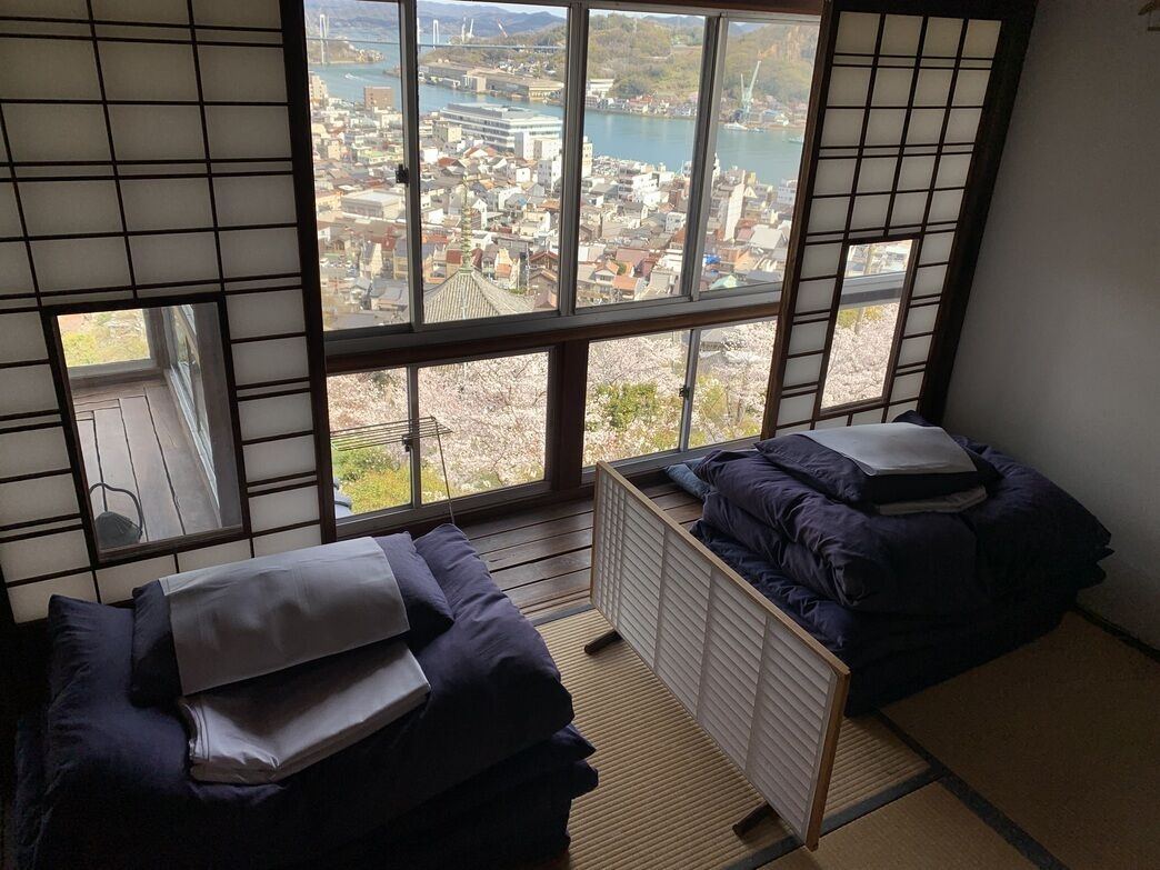 A room with a large window, a bed, and a radiator.