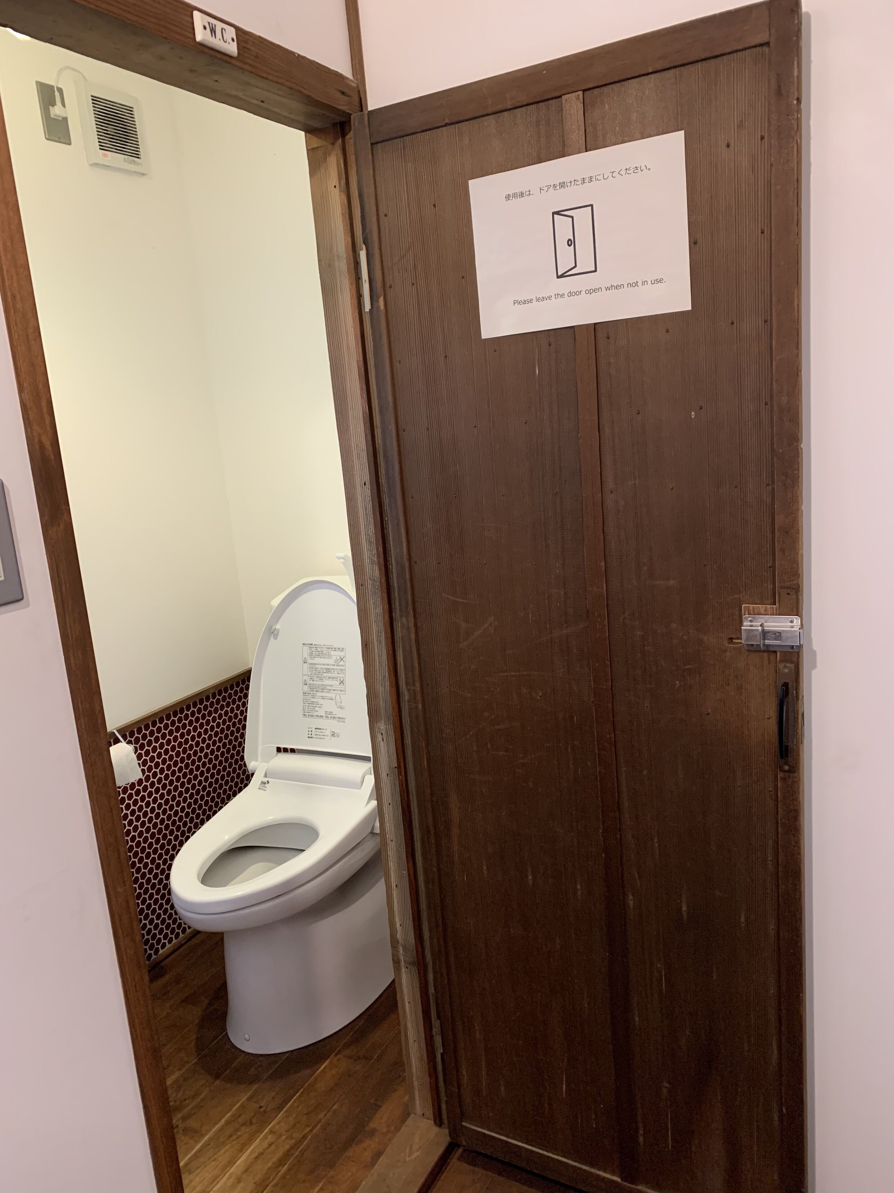 A wooden door with a sign instructing to leave the door open when not in use.