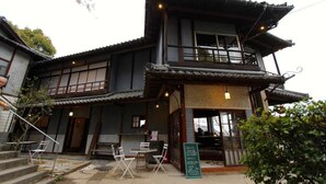 A traditional Japanese building with a two-story structure, wooden exterior, and a balcony. - Onomichi Guest House Miharashi-tei - Hostel (Onomichi)