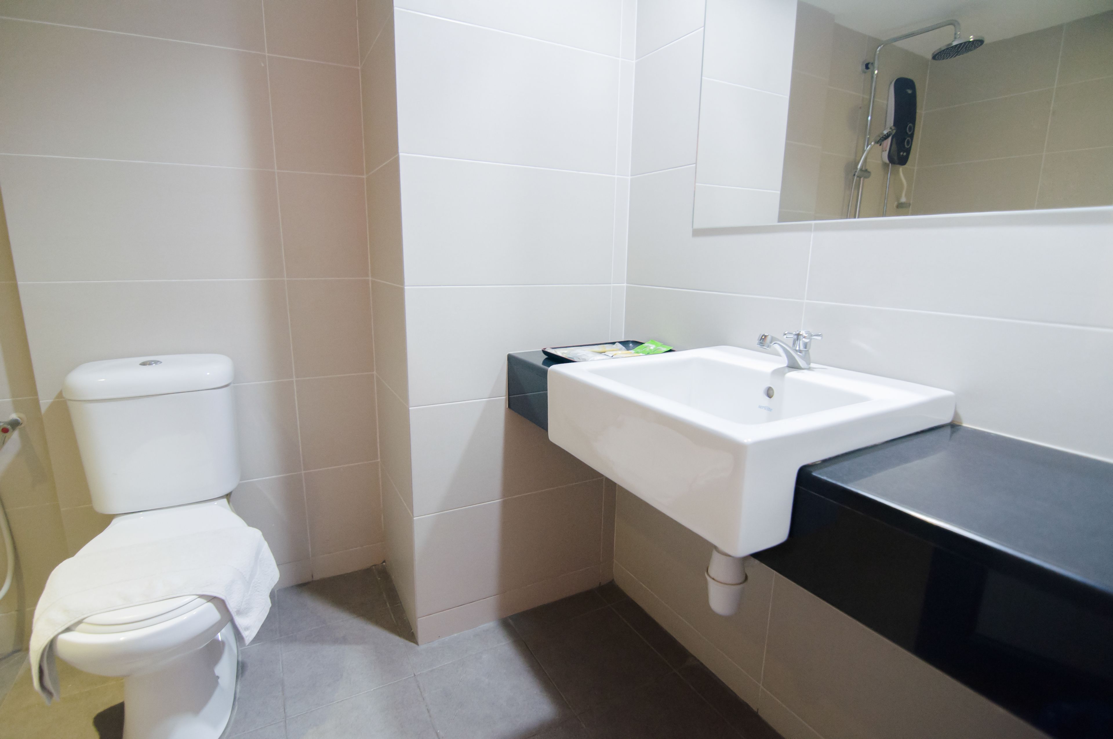 Een badkamer met toilet, wastafel en douche.