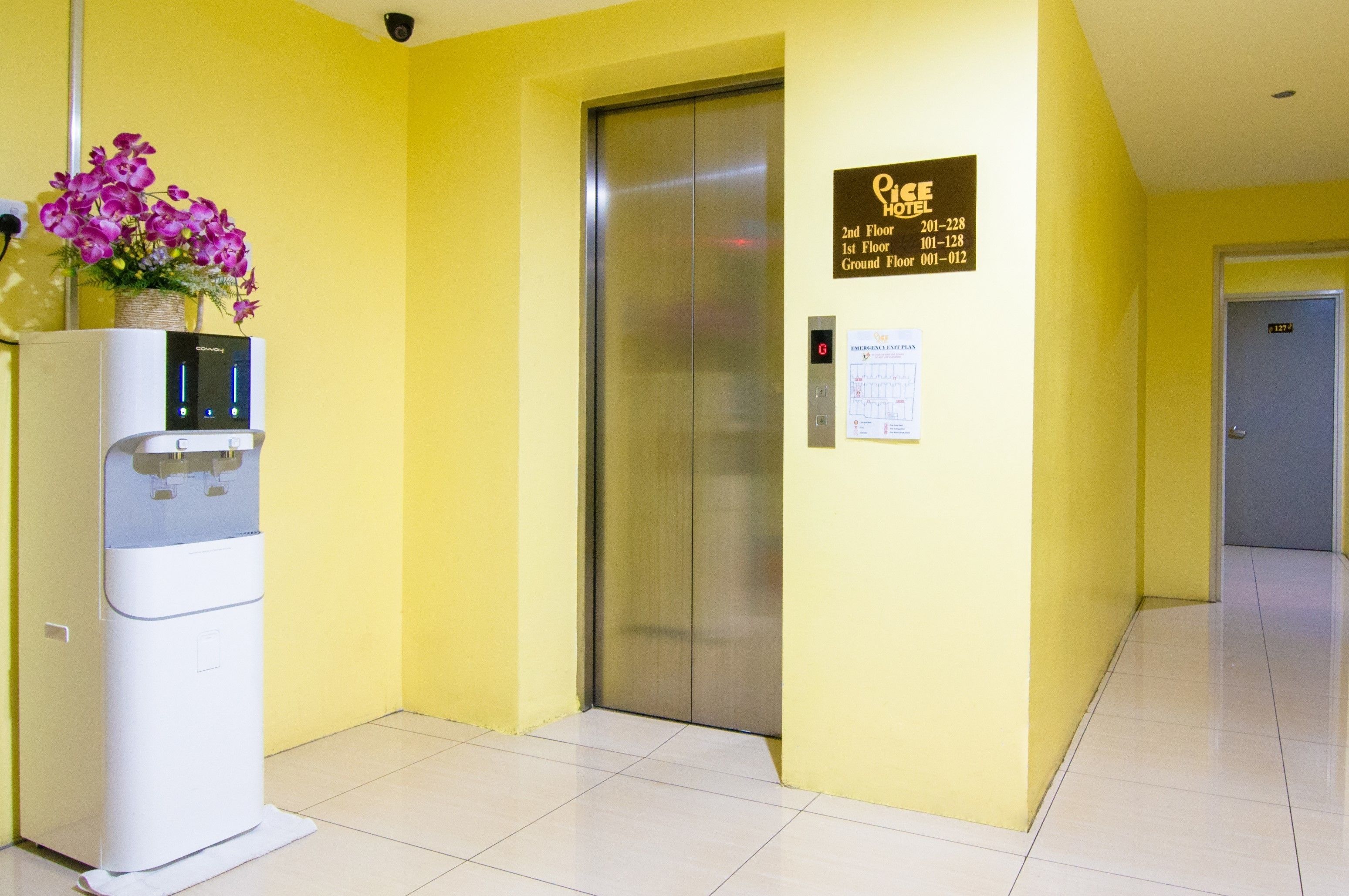 An elevator in a hotel lobby with a water dispenser and a sign indicating the 1st and 2nd floors.
