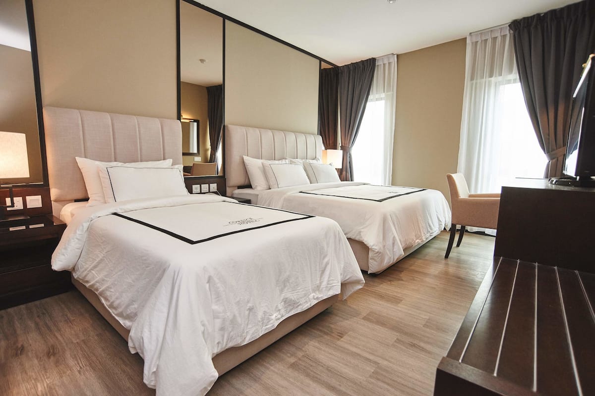 Una habitación de hotel con dos camas, un escritorio y una silla.