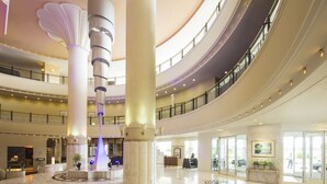 A spacious lobby with high ceilings, large columns, and a central light feature. - Miyazaki Kanko Hotel (Miyazaki)