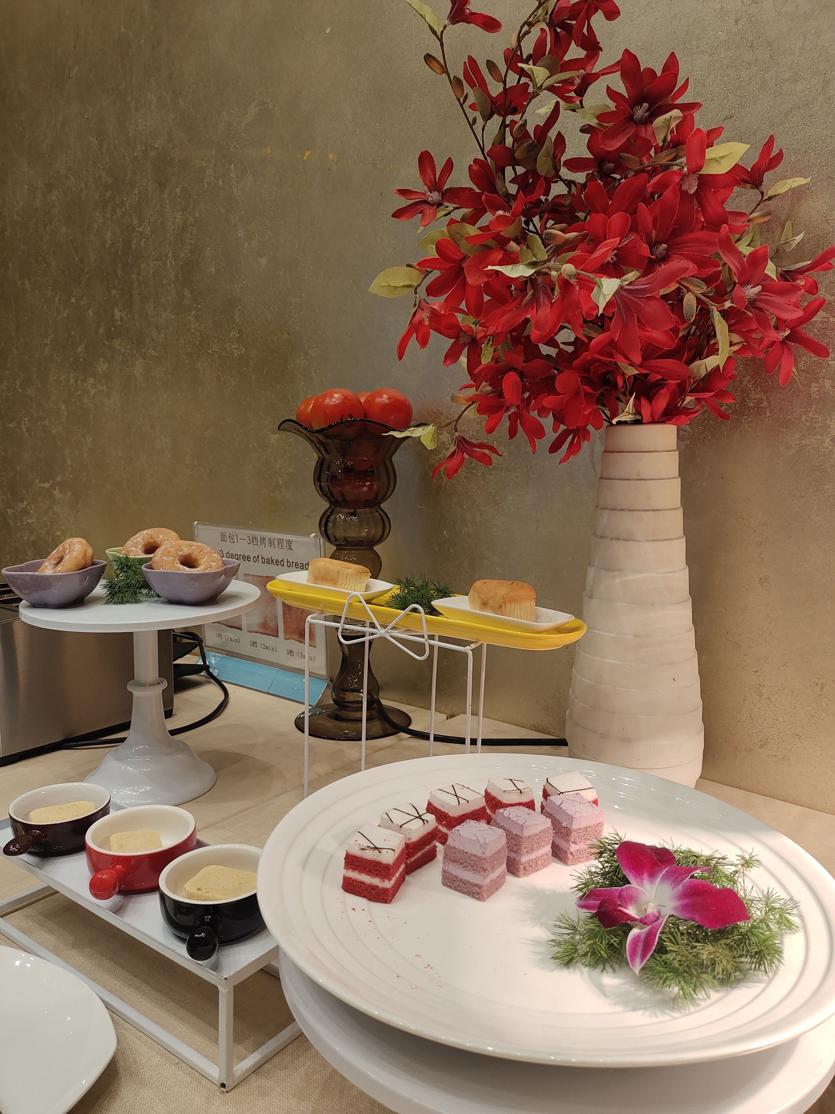 Ein reichhaltiges Buffet mit verschiedenen Speisen und einer dekorativen Vase mit roten Blumen.