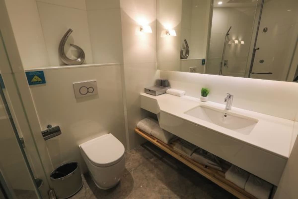 A modern bathroom with a toilet, sink, and shower.