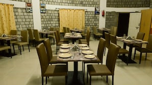 Un espace repas comprenant plusieurs tables et chaises, disposées de manière à créer un aménagement spacieux.