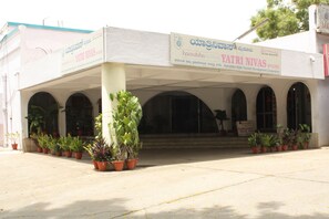 Un edificio con un letrero que dice "Yatri Nivas" y "Karnataka State Tourism Development Corporation".