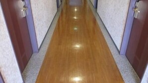 Un couloir doté d’un plancher en bois et de murs aux couleurs claires.
